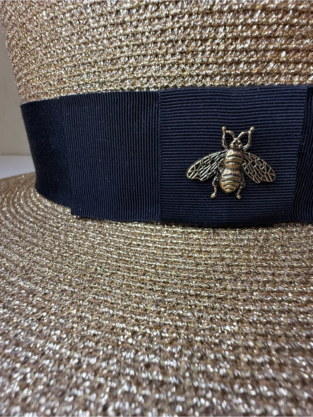 Gucci bee detail hat featuring a gold toned metallic woven design and blk ribbon